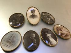 A set of seven Edwardian gilt-metal oval hanging frames, each with ribbon-tied reeded border,