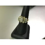 A striking diamond cluster ring, the central marquise-cut claw-set stone weighing approx. 0.65