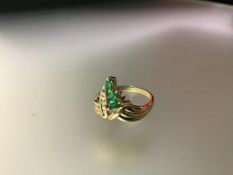 An emerald and diamond cluster ring, the three graduated marquise-cut emeralds claw set beside a