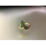 An emerald and diamond cluster ring, the three graduated marquise-cut emeralds claw set beside a