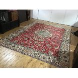 A modern Persian carpet, the central ivory medallion within a madder field decorated with