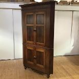 A large 19th century mahogany standing corner cupboard, c. 1840, the projecting cornice with egg and