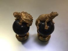 A pair of decorative carved, parcel-gilt and ebonised table ornaments, purchased from Bergdorf