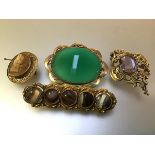 A group of four 19th century brooches comprising: one centred by an oval stone of amethyst colour in