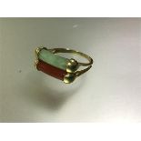 A jade and carnelian ring, the twin bars of semi-precious stone with yellow gold terminals on