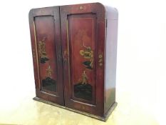 A scarlet lacquered table cabinet, c. 1920 in the manner of Liberty & Co., the arched top above a