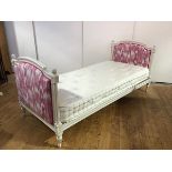 A French white-painted day bed in the Neo-Classical taste, the arched ends with padded pink