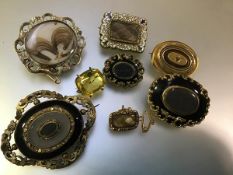 A group of 19th century mourning brooches comprising: three oval, with black enamel and hair