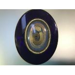 A large 19th century blue glass and seed pearl mourning brooch, oval, the central glazed compartment