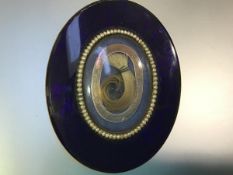 A large 19th century blue glass and seed pearl mourning brooch, oval, the central glazed compartment