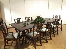 A mahogany twin pedestal dining table and set of eight chairs, the table enclosing two additional