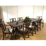 A mahogany twin pedestal dining table and set of eight chairs, the table enclosing two additional