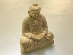 A Chinese carved limestone figure of a seated buddha, modelled with hands folded. 16.5cm