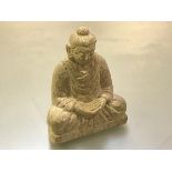 A Chinese carved limestone figure of a seated buddha, modelled with hands folded. 16.5cm