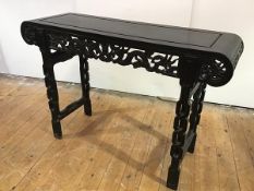 A Chinese hardwood altar table, early 20th century, the incised rectangular top with scroll ends and