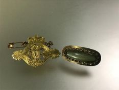 A late 19th century yellow metal brooch modelled as a monogram under a crown, unmarked and