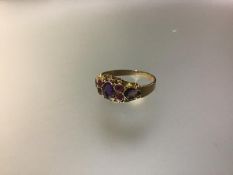 An amethyst cluster ring, centred by an oval-cut stone flanked by pairs of round-cut stones, the