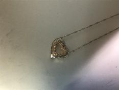 A diamond-set heart pendant, the open heart set to the exterior in white gold with a line of small