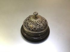 A late Victorian silver-plated lady's desk bell or counter bell, pierced with scrolls, masks and