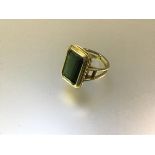 A single stone ring set with an emerald-cut green stone, possibly a beryl, mounted in (unmarked)