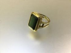 A single stone ring set with an emerald-cut green stone, possibly a beryl, mounted in (unmarked)