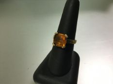 A single stone fire opal ring, the square-cut stone claw-set on a 9ct yellow gold band. 5.3 grams,