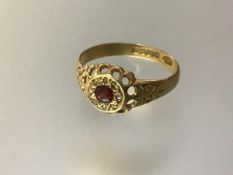 An early 20th century ruby and diamond ring, the central round-cut ruby within an engraved