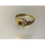 An early 20th century ruby and diamond ring, the central round-cut ruby within an engraved