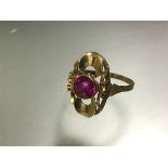 A single stone ruby ring, the round-cut stone centred on a modernist pierced shaped mount, on a