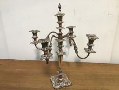 A silver plate on copper candelabrum, with four scrolling branches radiating from a central stem,