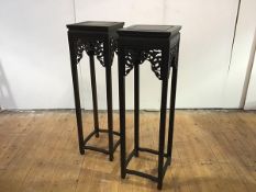 A pair of tall Chinese hardwood jardiniere stands, each with incised square top and pierced frieze