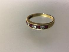 A seven stone ruby and diamond ring, the line of four round-cut rubies spaced by three round