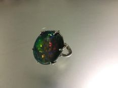 A striking and large single stone opal ring, the oval-cut Lightning Ridge black, five colour opal