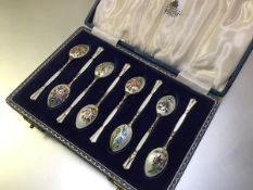 A cased set of eight silver and enamel coffee spoons, Birmingham 1958, each bowl decorated to the