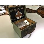 A small picnic box for two, c. 1920, the leather case with wood-lined interior, fitted with white