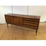 A Danish rosewood sideboard, c. 1960, the rectangular top above a bank of four drawers and a pair of