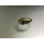 A 19th century multi-stone ring, set to the centre with a pink/purple round-cut stone between