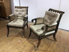 A pair of ebonised and parcel-gilt library bergeres of Regency design with fluted top rails with