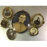 A group of World War I and other military locket brooches in gold and yellow metal comprising: an