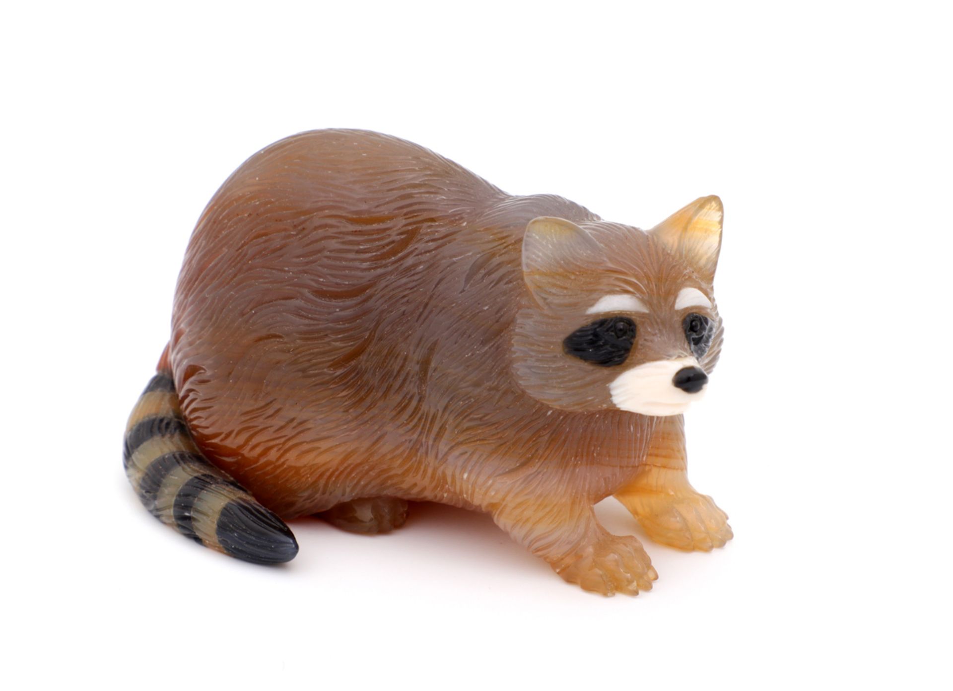 AN AGATE RACCOON Carved agate on several shades, Fabergé style, 20th Century. Length: 9 cm.