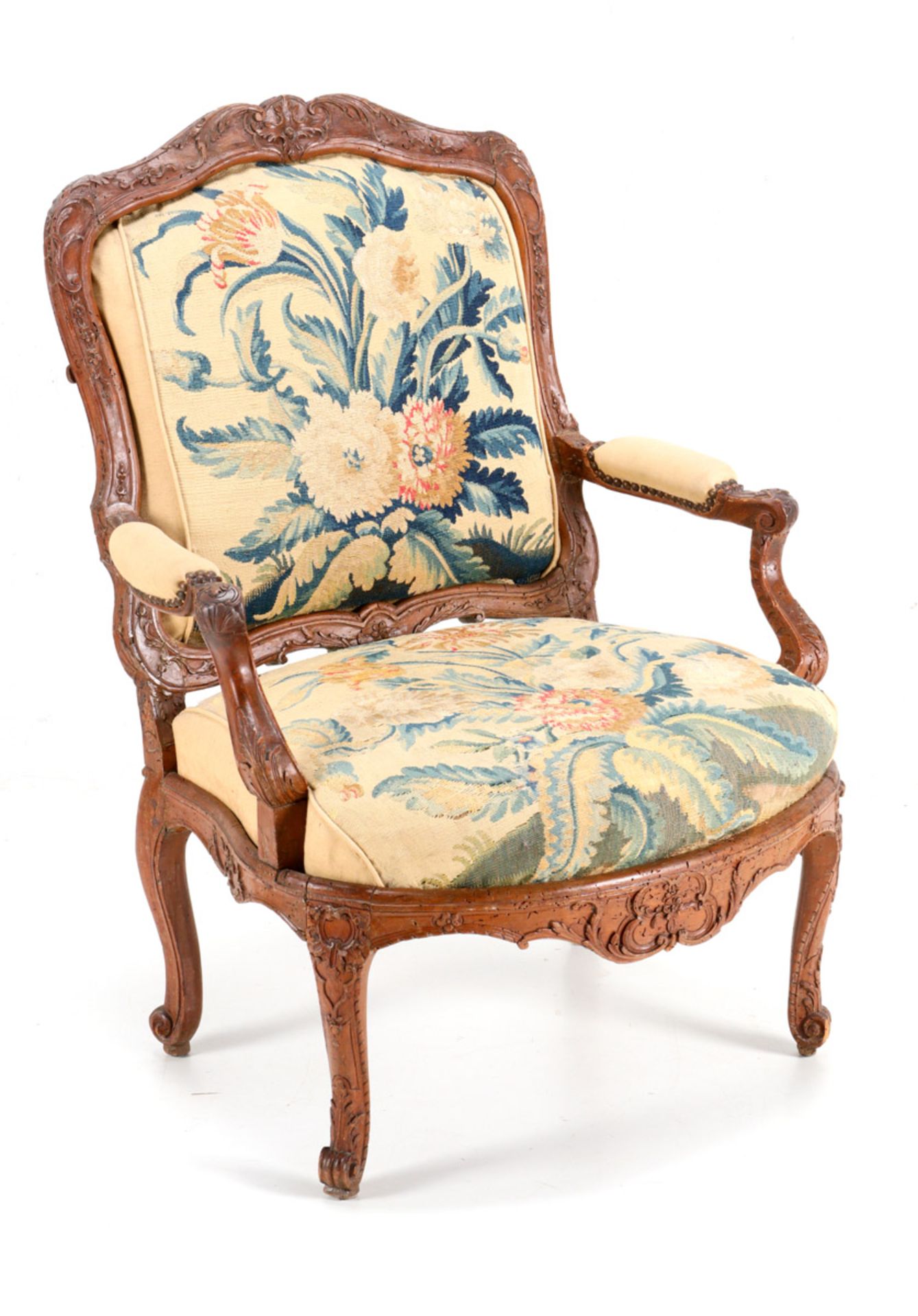 AN IMPORTANT REGENCE FAUTEUIL Walnut, profusely carved decoration with floral motifs. Lined with