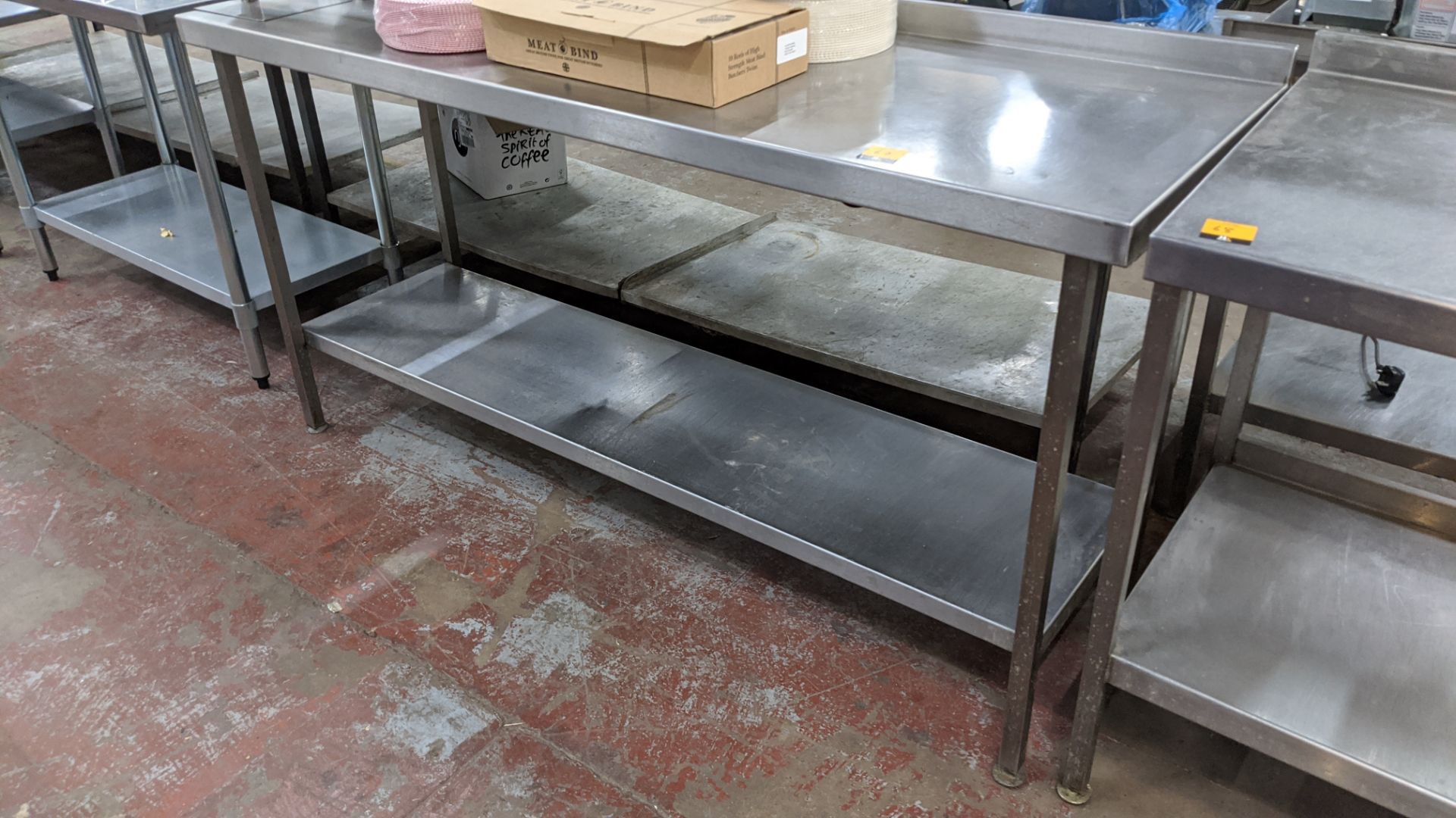 Stainless steel twin tier table with top measuring approximately 1790mm x 600mm