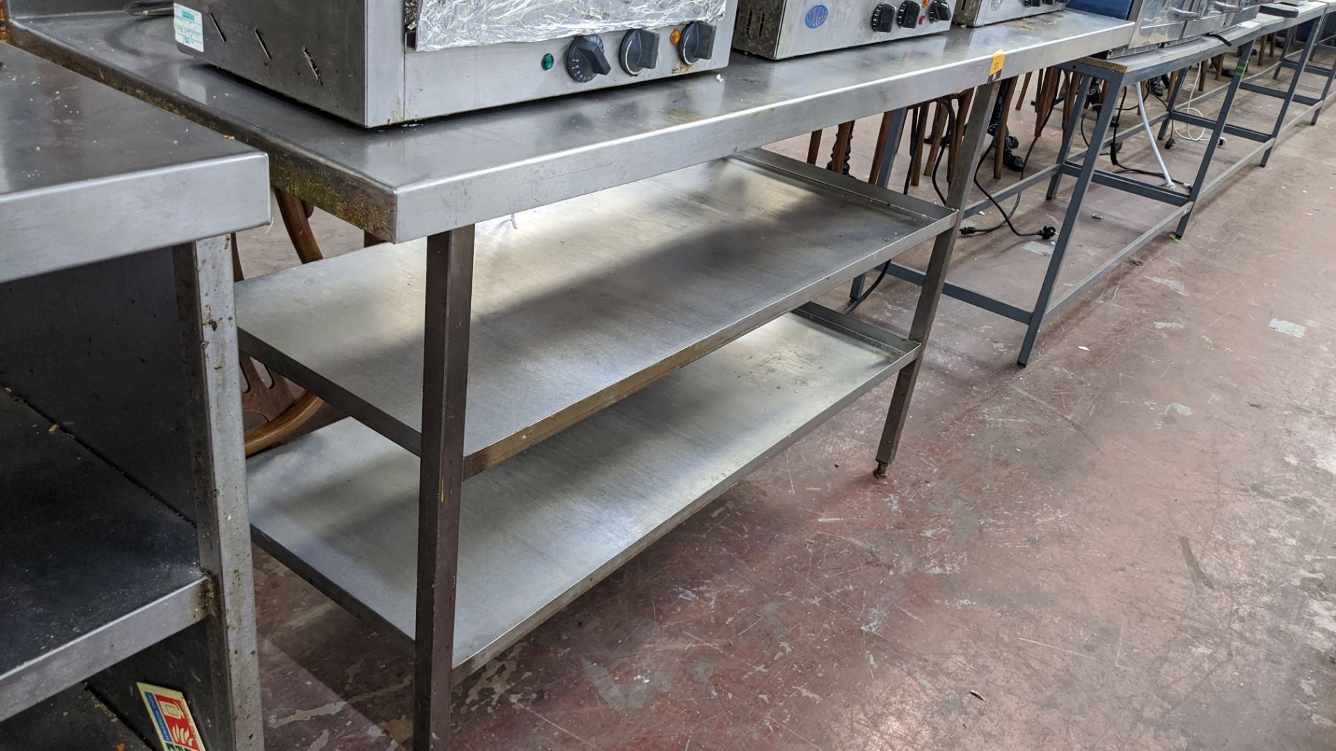 Stainless steel table with shelves across approx. two thirds of the base. Table top measures approx