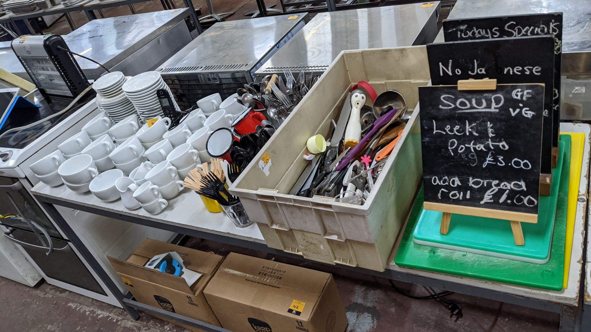 The contents of a table comprising white cups & saucers plus cutlery, utensils, chopping boards, min - Image 2 of 6