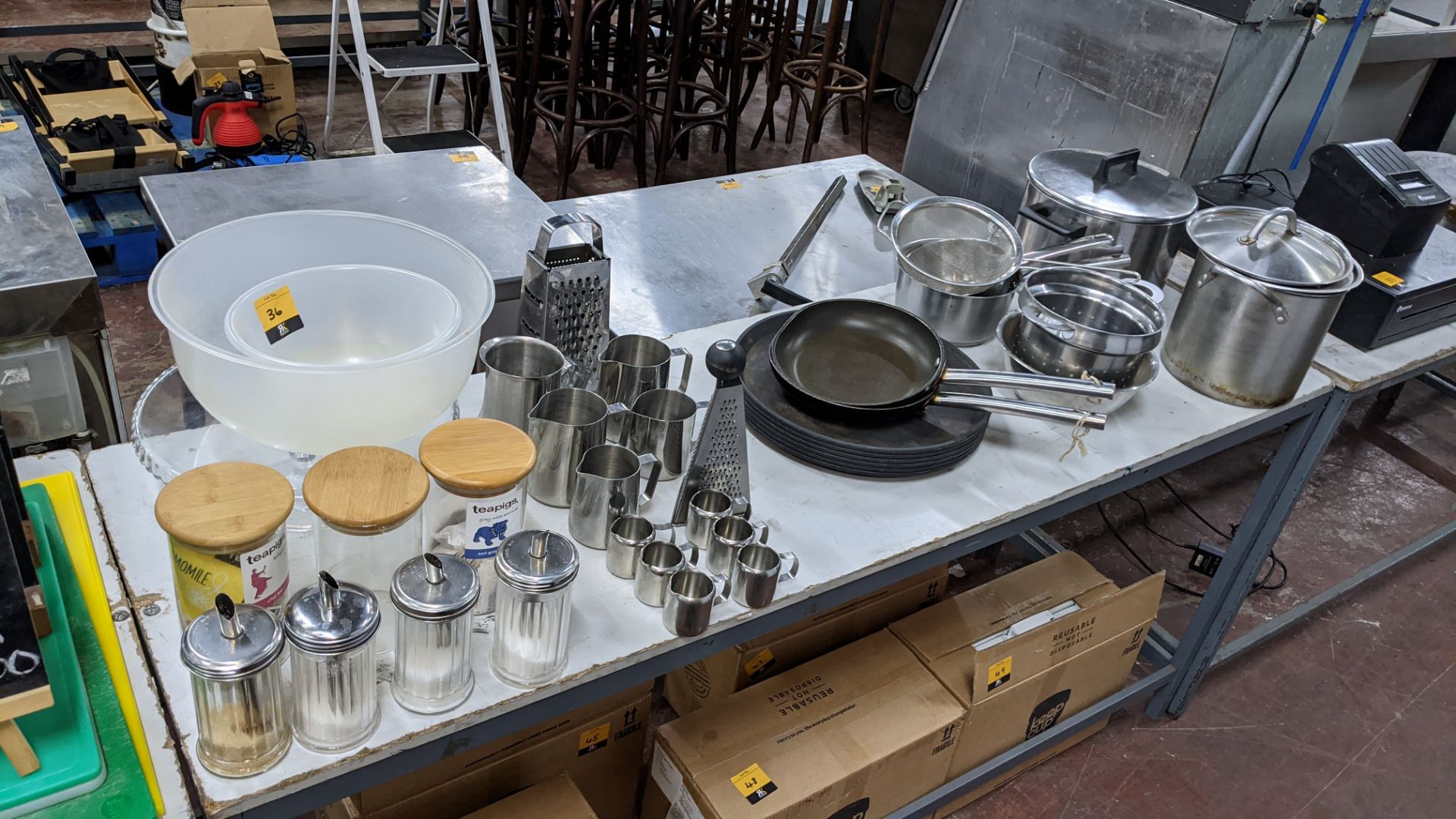 The contents of a table comprising jars, bowls, sugar dispensers, milk jugs, trays, strainers, pans