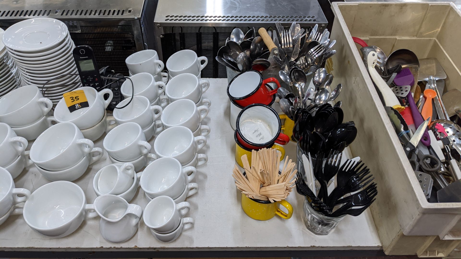 The contents of a table comprising white cups & saucers plus cutlery, utensils, chopping boards, min - Image 4 of 6