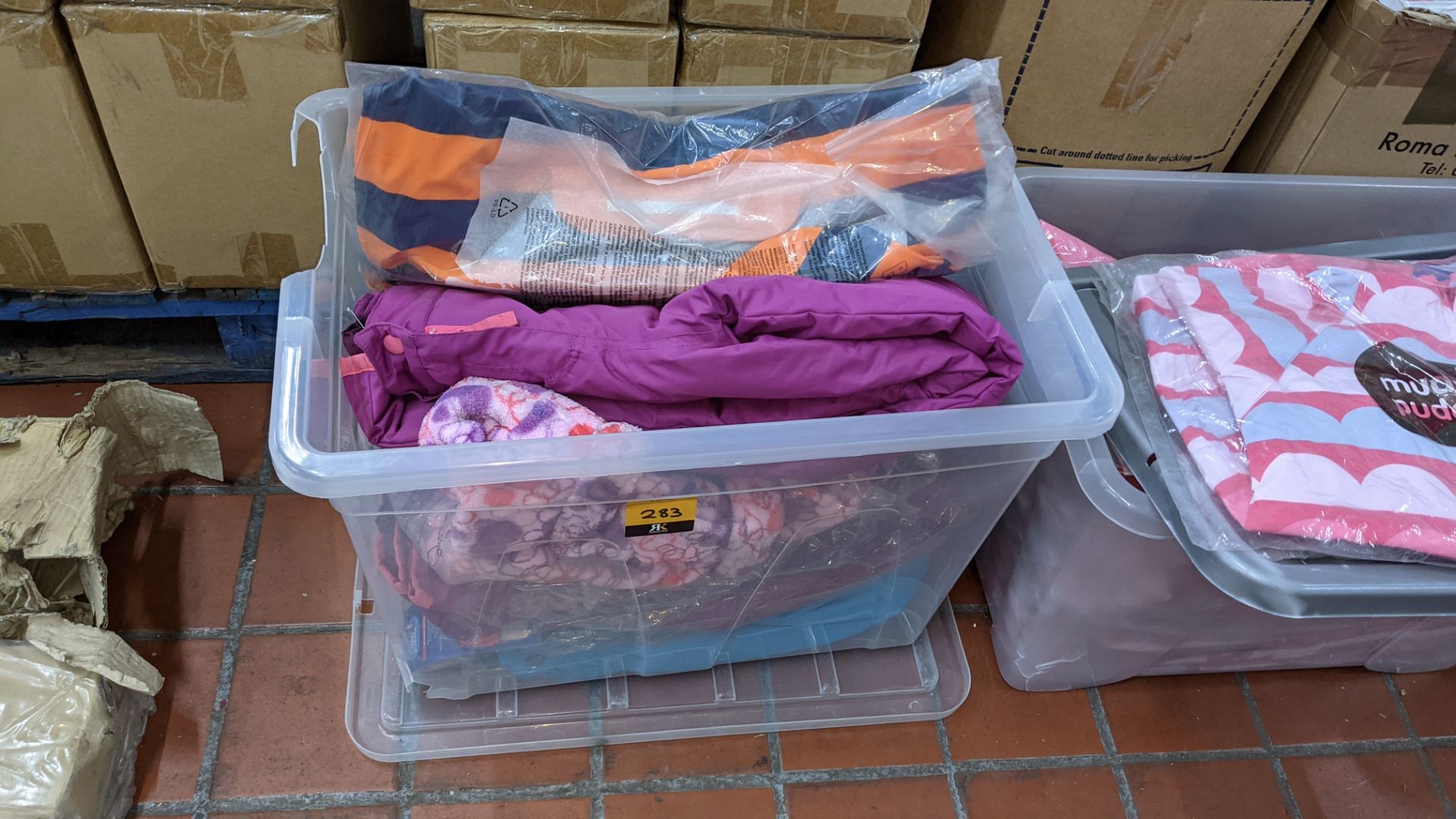 The contents of a crate of assorted children's & adults clothing