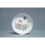 A Chinese famille rose 'ruby back' saucer dish with butterflies among flowers, Yongzheng