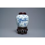 A Chinese blue and white 'dragon and phoenix' jar with wooden cover and stand, Kangxi