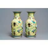 A pair of Chinese yellow-ground famille rose relief-decorated vases, 19th C.